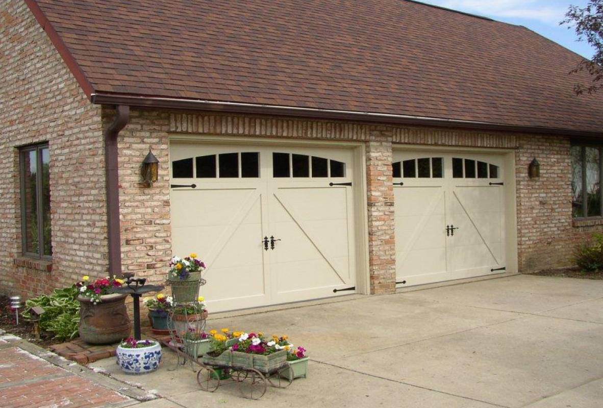 carriage garage doors in white with flowers outside