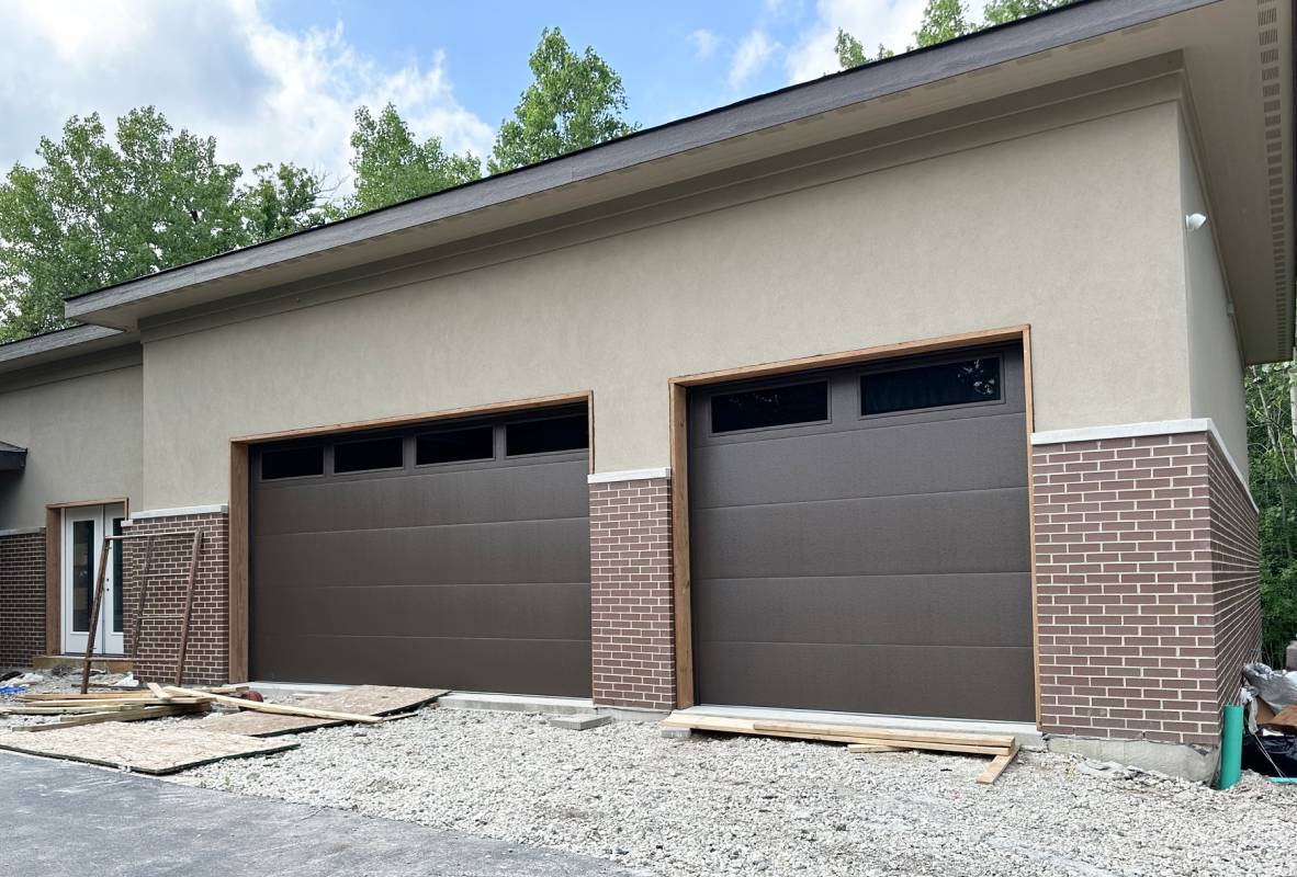 Brick and stone house with two brown garage doors