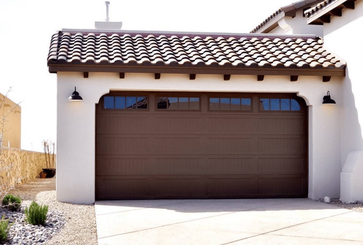 Medterranean style white house with brown garage door