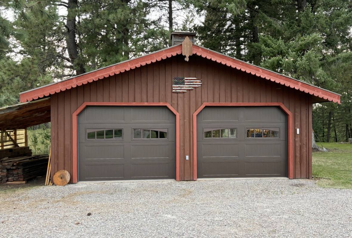 Small outhouse with two brown garage doors