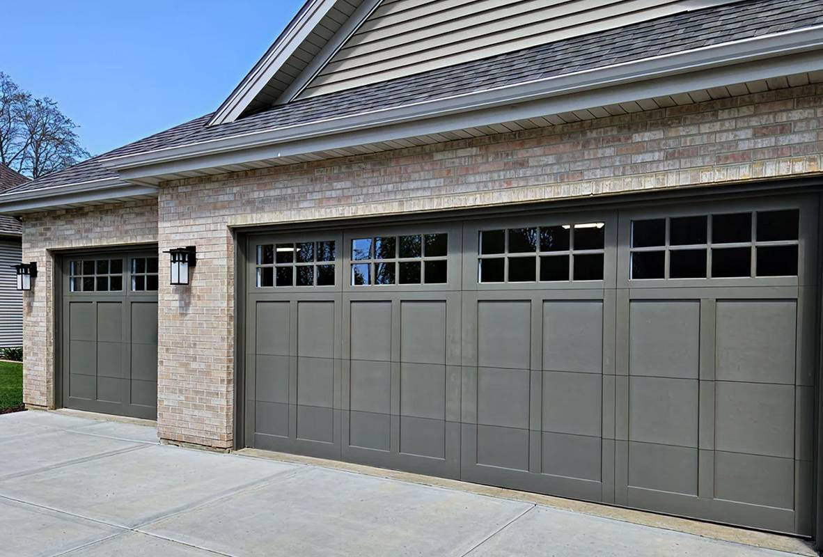Light brick house with two bronze garage doors