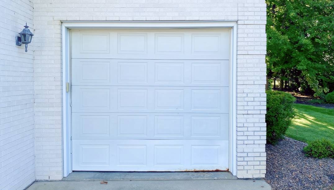 before - white brick garage with old white door