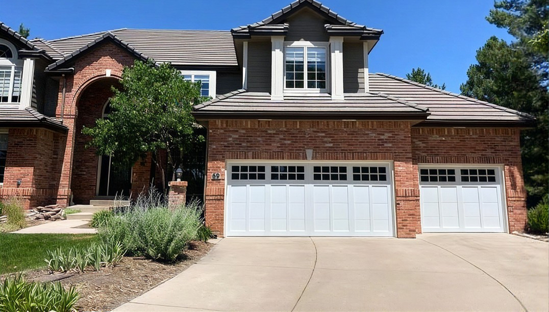 after -  brick home with white garage doors - Steel Overlay Carriage House