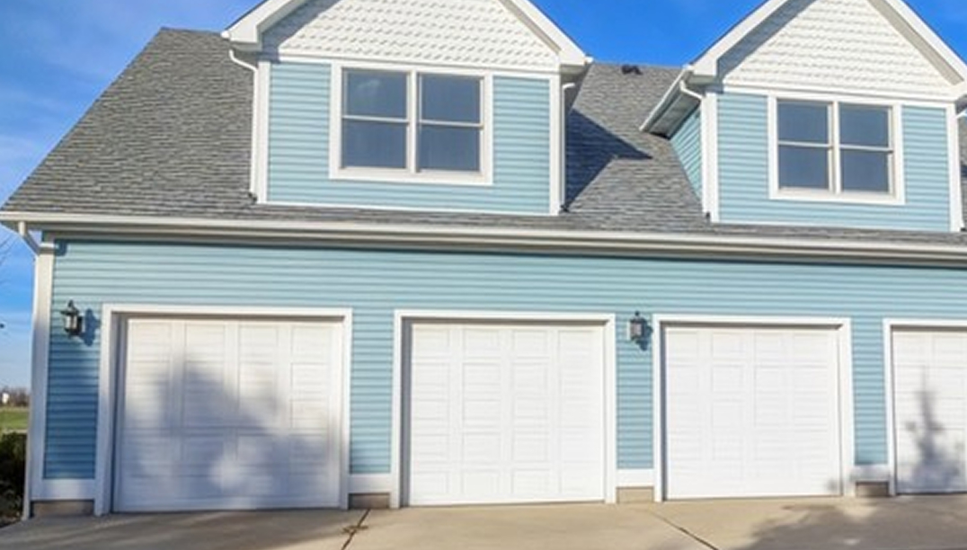 before - blue home with white garage doors
