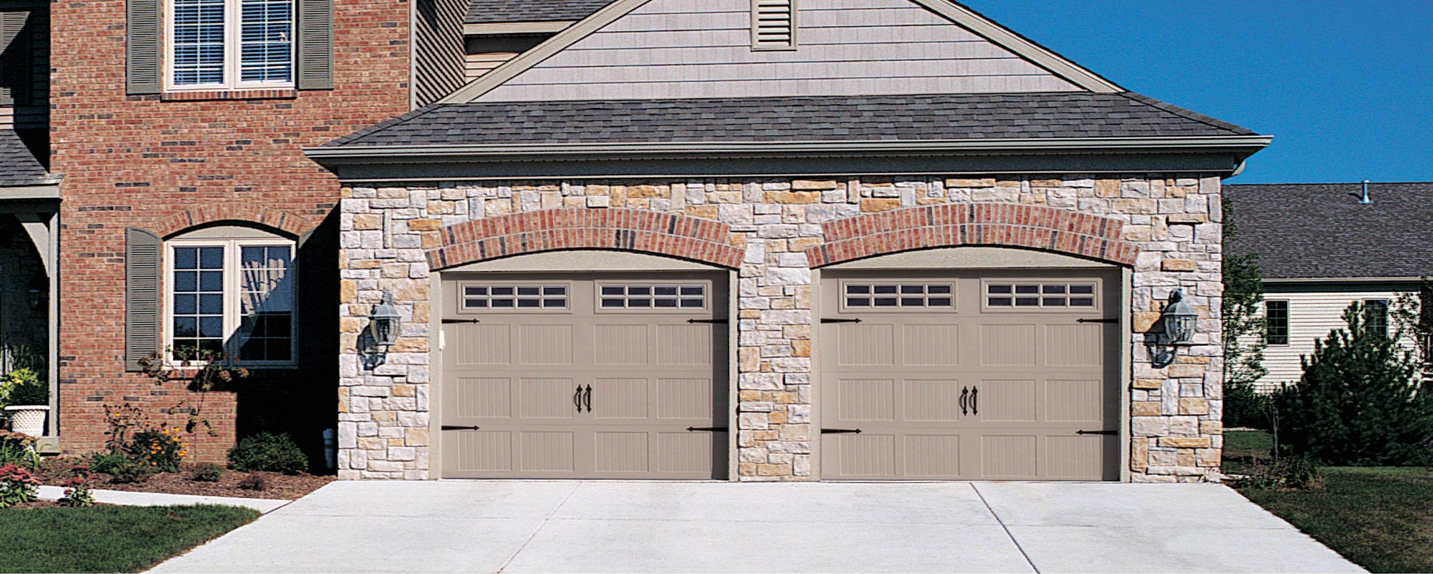 Stamped carriage house garage doors in sandstone with brick
