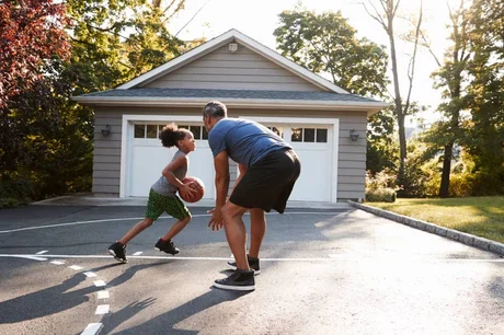 people playing basketball in front of garage doors