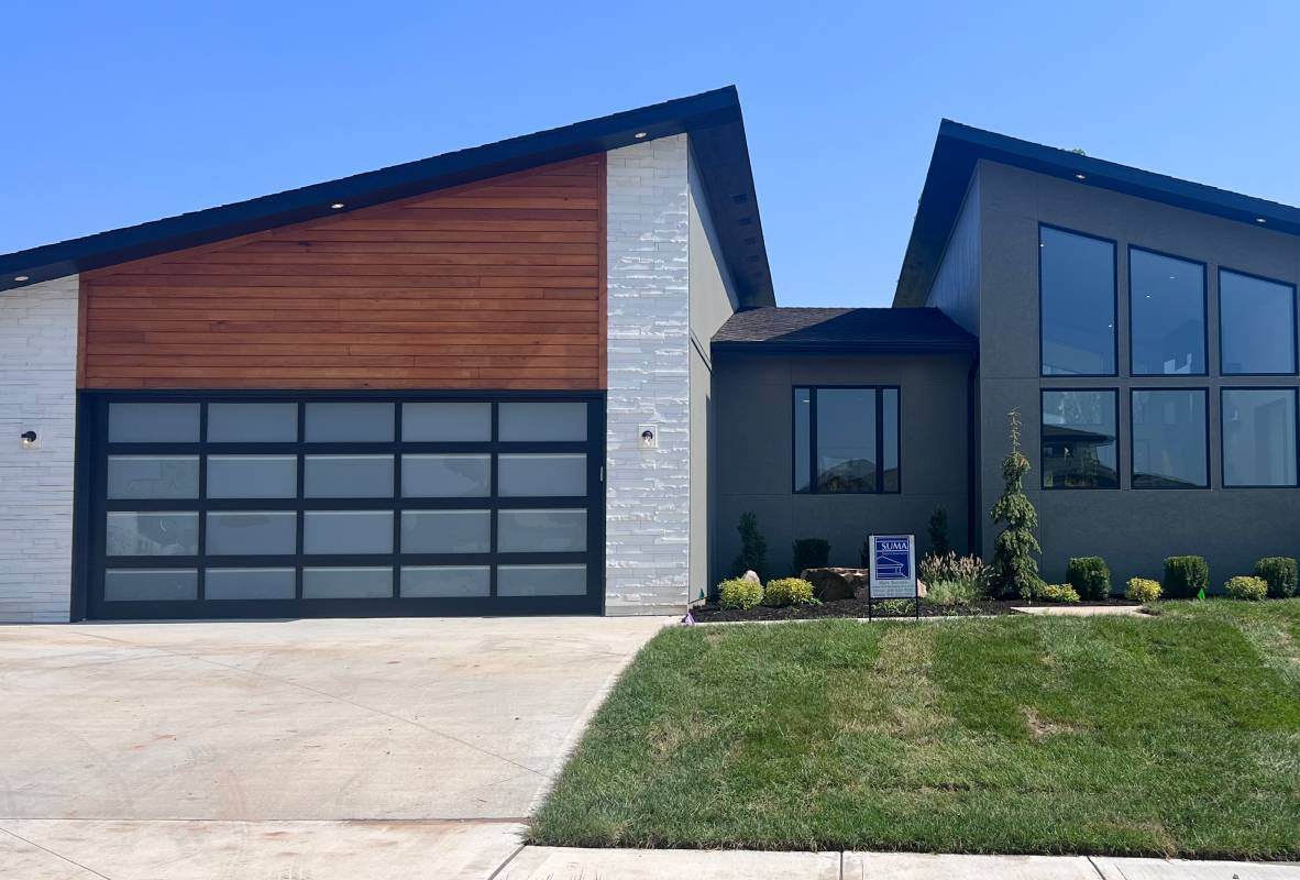 Full-view aluminum garage door in powdercoat black mid-century house