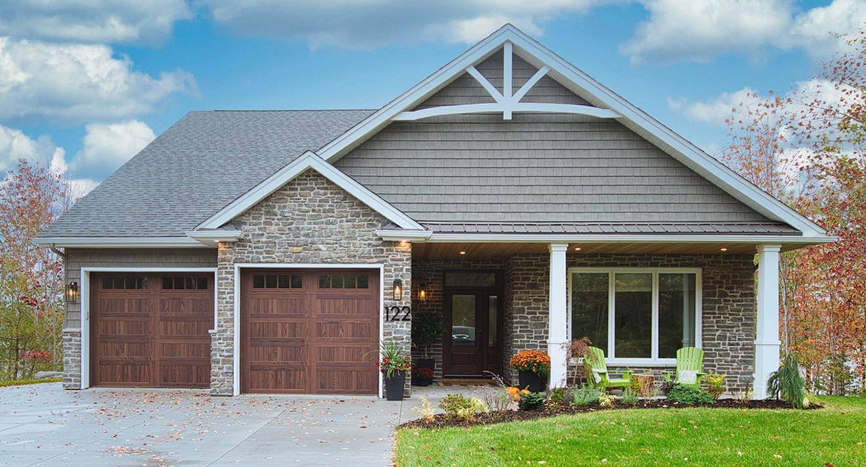 A single storey modern tudor style house with two woodtone garage doors