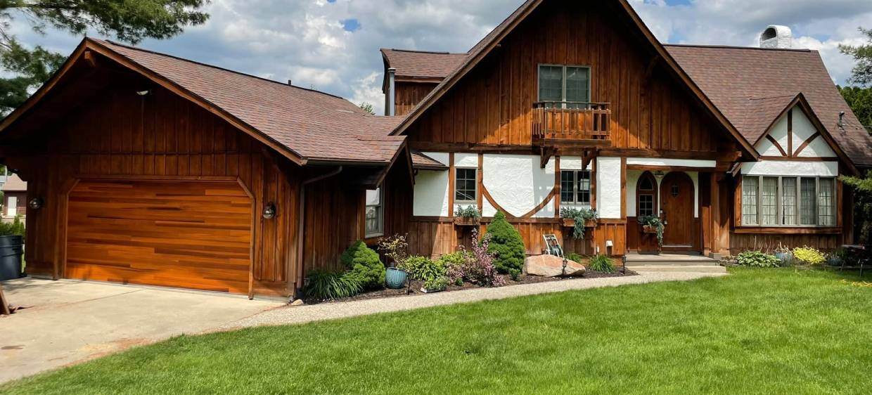 Faux wood garage door with traditional tudor house