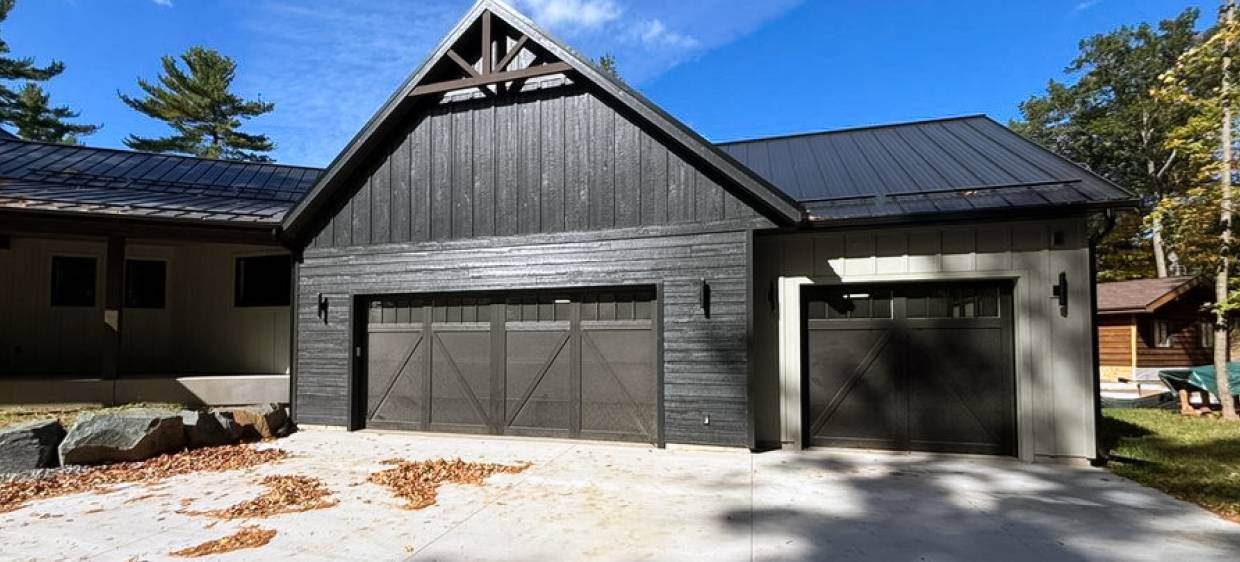 Overlay carriage house garage door in black tudor style house