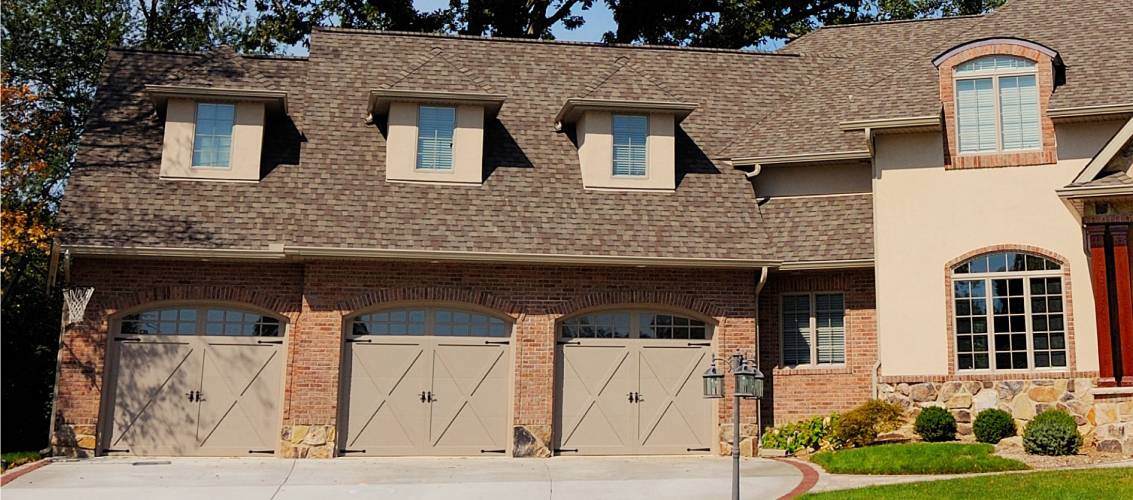 Overlay carriage house garage door in tan tudor style
