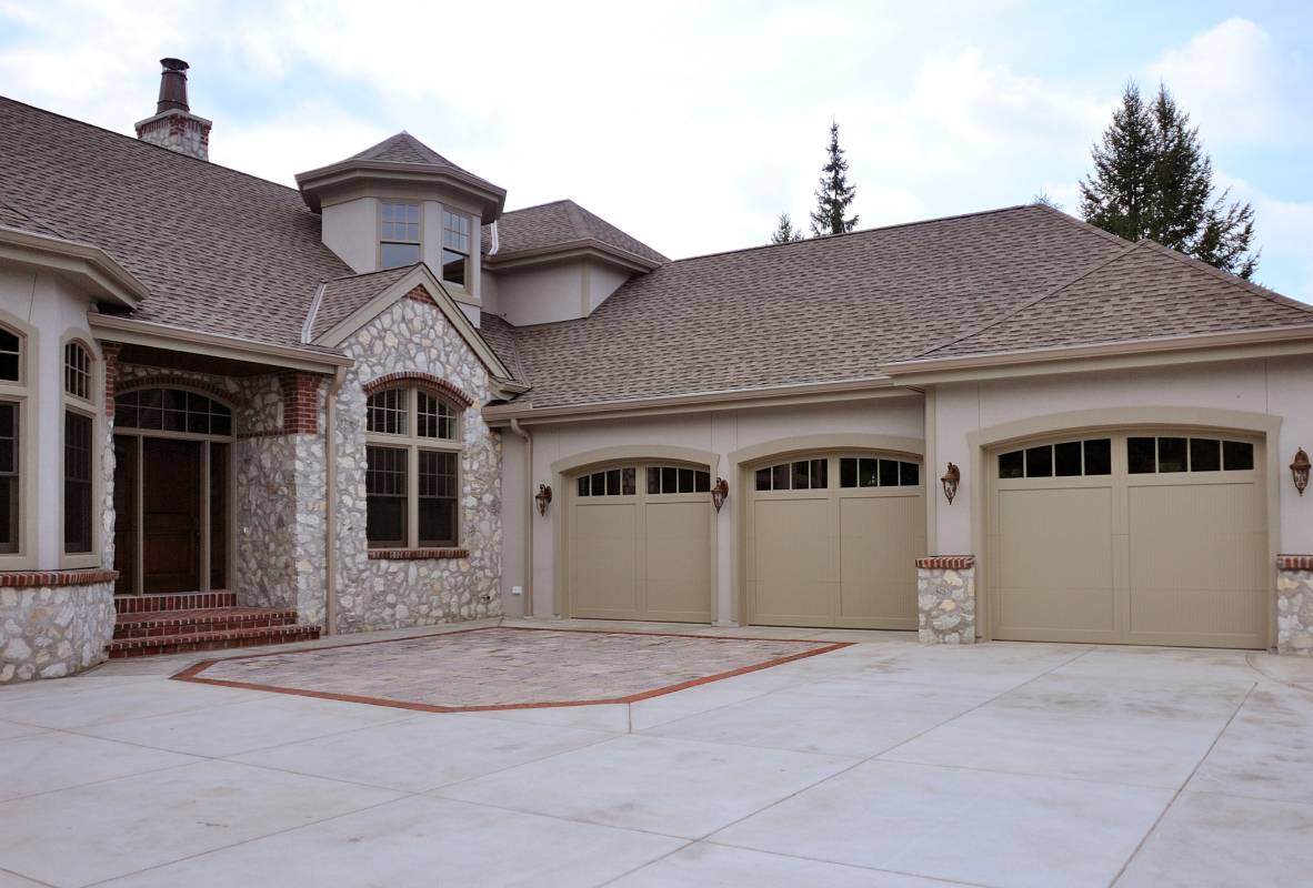 Overlay carriage house garage doors in tan tudor style